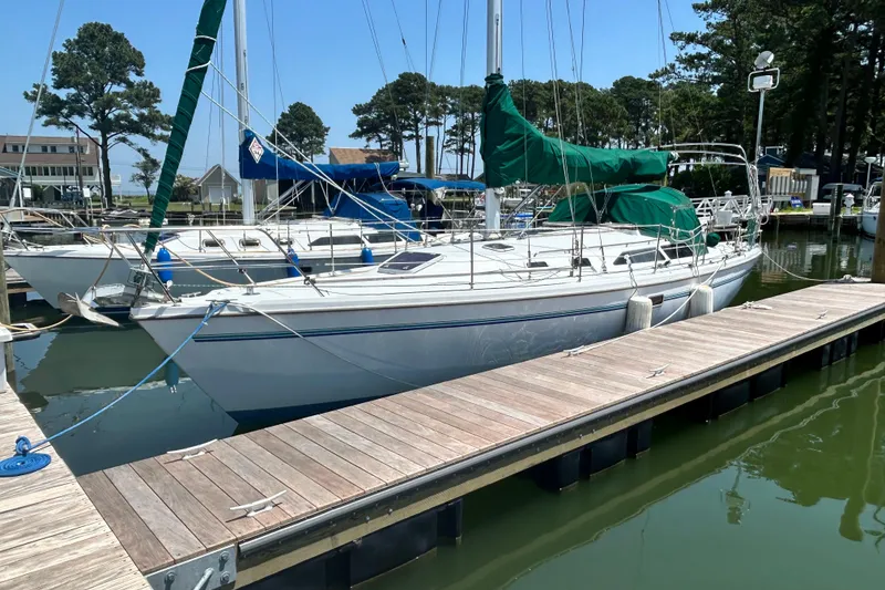 Slide: The Image of 1998 Catalina 36 MkII sailboat docked at a marina with green covers. - 3