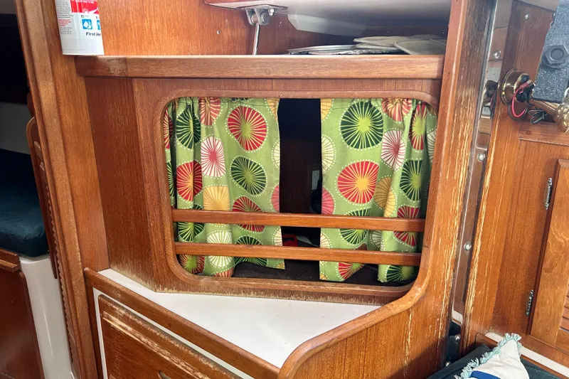 Slide: The Image of Interior of a 1998 Catalina 36 MkII sailboat with colorful curtains and wooden cabinetry. - 82