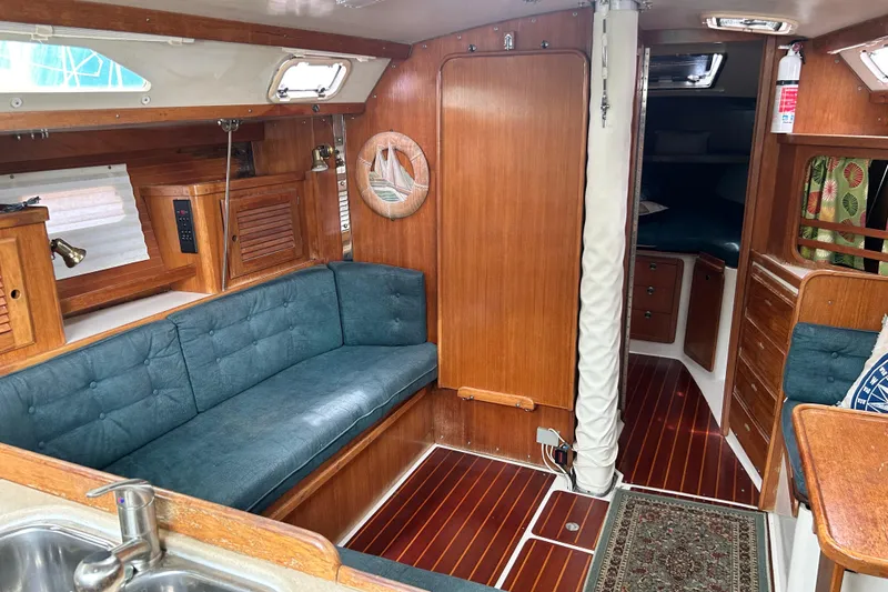 Slide: The Image of Interior of a 1998 Catalina 36 MkII sailboat with wood paneling and blue seating. - 53
