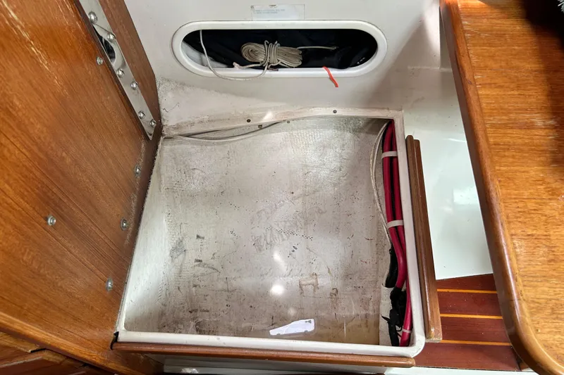 Slide: The Image of Interior storage compartment of a 1998 Catalina 36 MkII sailboat, featuring wooden and fiberglass elements. - 56