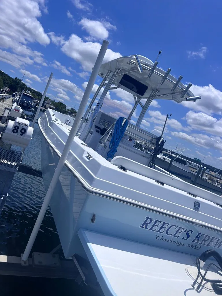 Slide: The Image of A 1993 Aquasport 2300 Center Console boat docked on a sunny day. - 4
