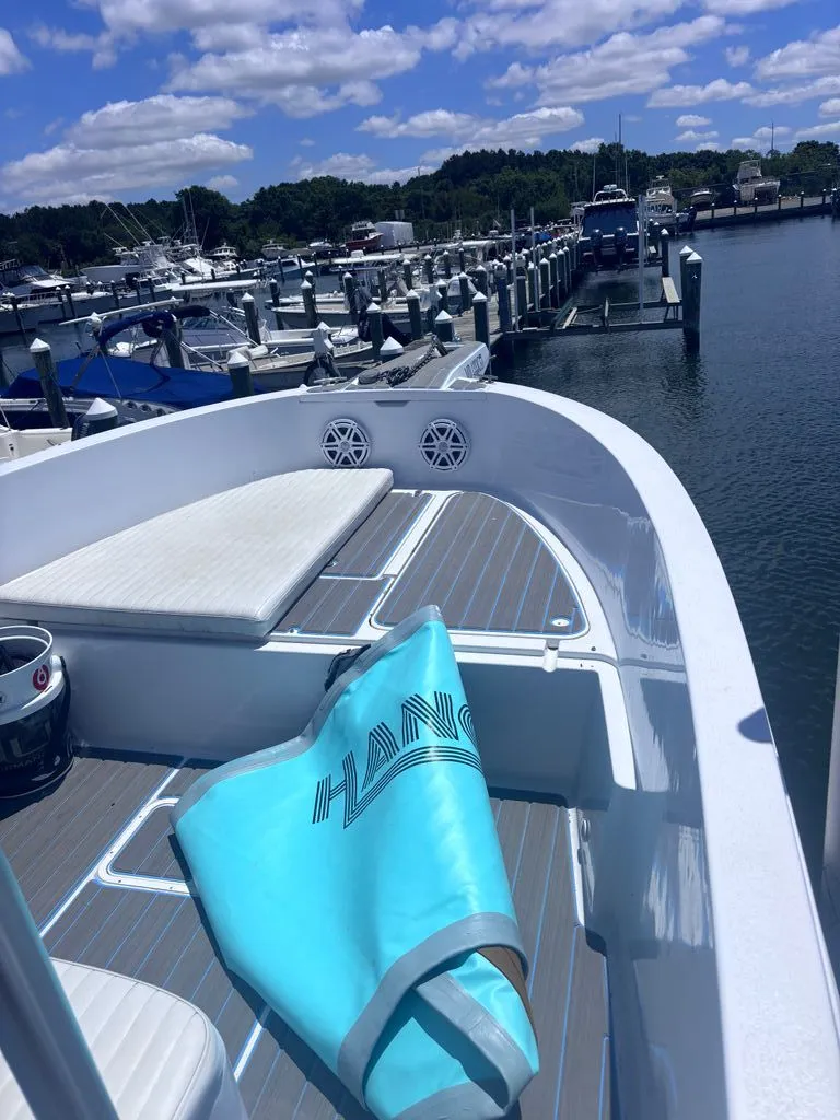 Slide: The Image of 1993 Aquasport 2300 Center Console at a marina, with a blue towel on the deck. - 1