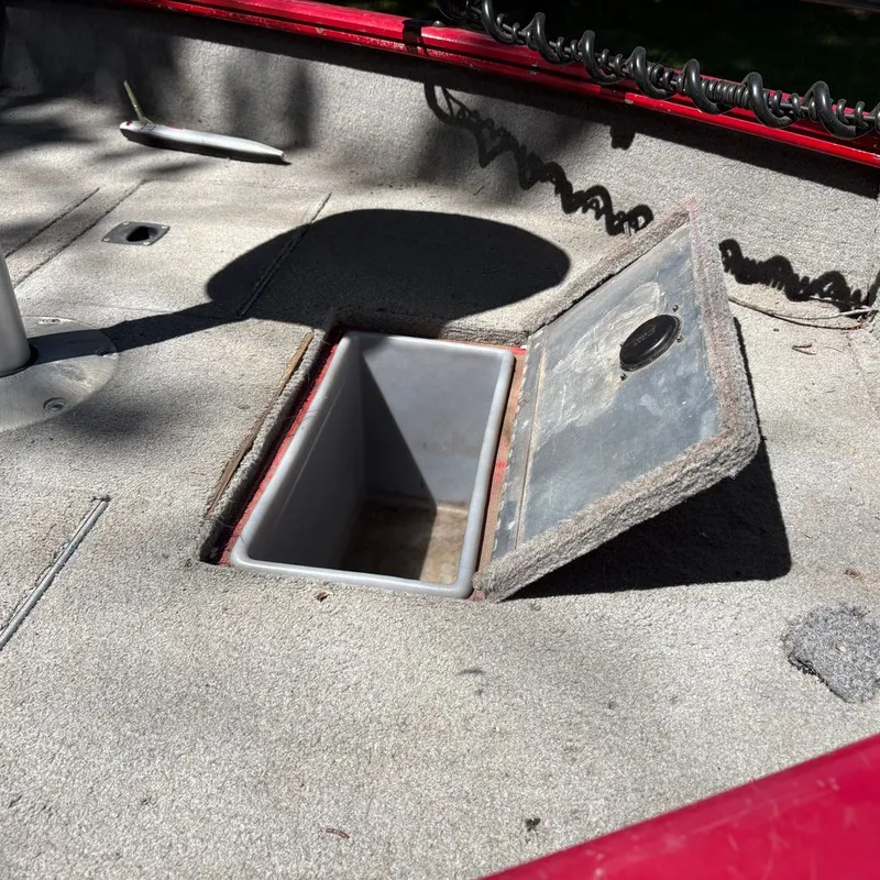 Slide: The Image of Open storage compartment on a boat with gray carpeted flooring. - 6