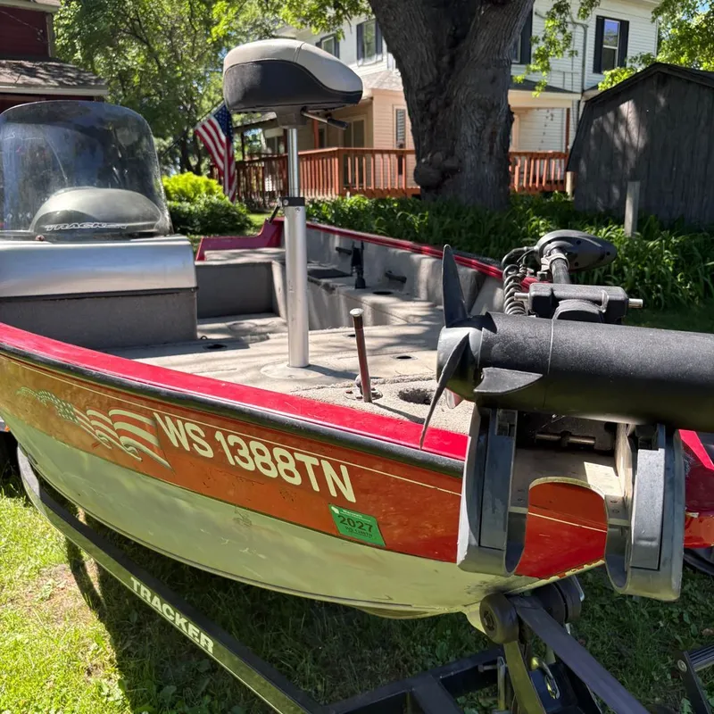 Slide: The Image of A red 2013 Tracker boat on a trailer in a yard. - 9