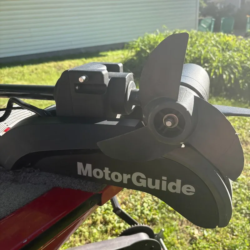 Slide: The Image of Close-up of a MotorGuide motor on a Tracker boat, surrounded by grass. - 11