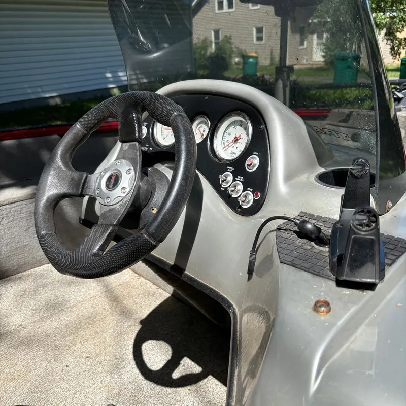 Slide: The Image of The image shows the cockpit of a 2013 Tracker Pro Guide boat with a steering wheel and gauges. - 5