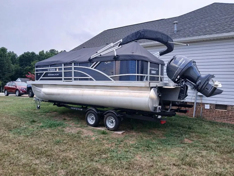 Slide: The Image of A Bennington 20SL pontoon boat is on a trailer next to a house. - 4
