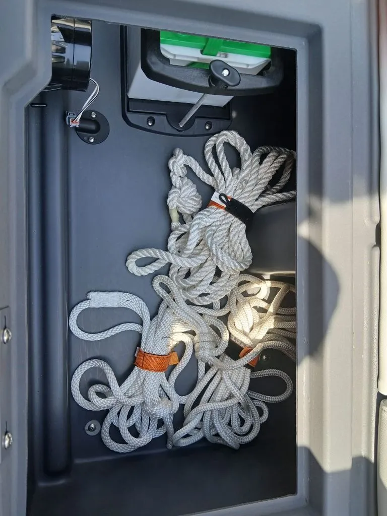 Slide: The Image of A storage compartment with several ropes and a device. - 27