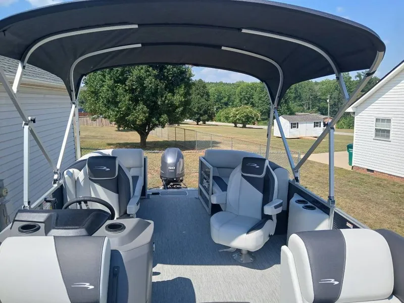 Slide: The Image of The image shows the interior of a Bennington 20SL pontoon boat with seating and a bimini top. - 18