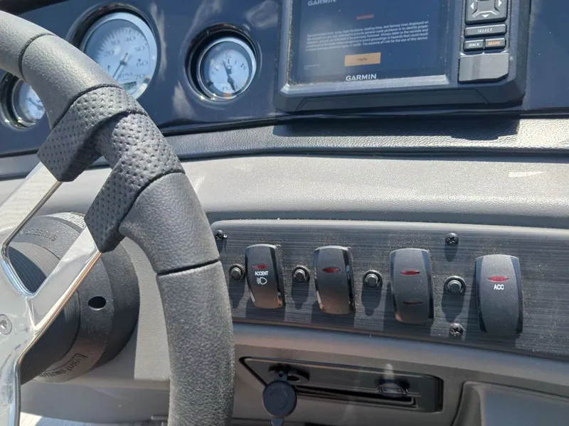 Slide: The Image of Dashboard of a Bennington 20SL with steering wheel, switches, and Garmin screen. - 13