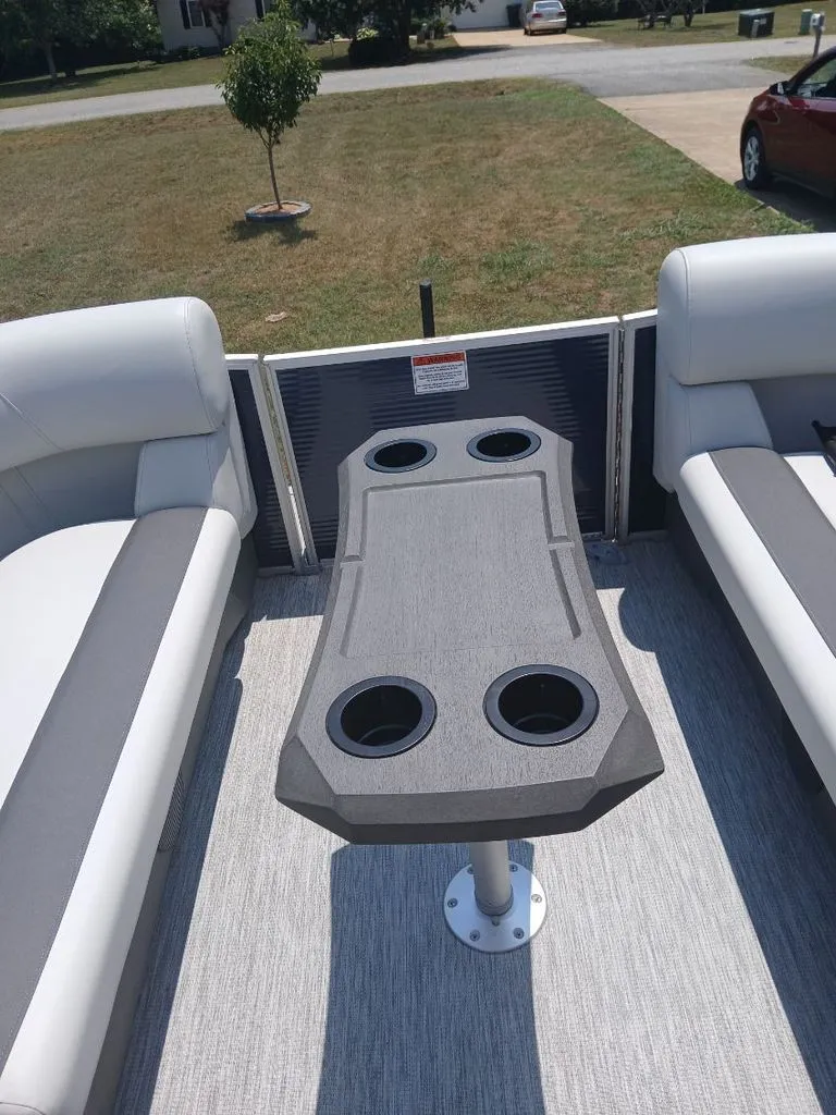 Slide: The Image of Interior view of a 2026 Bennington 20SL with a gray table and cup holders. - 17