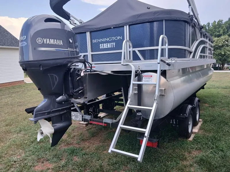 Slide: The Image of A Bennington 20SL pontoon boat with a Yamaha outboard motor sits on a trailer outdoors. - 32