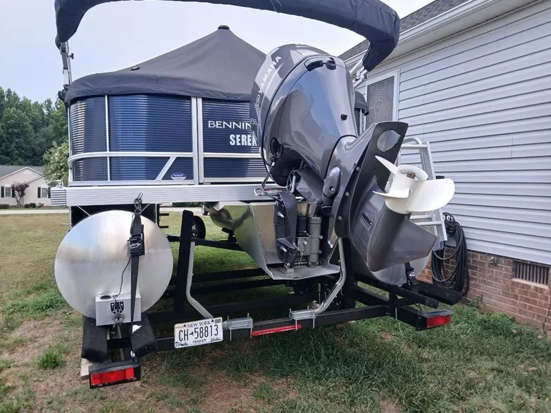 Slide: The Image of A Bennington 20SL pontoon boat on a trailer next to a house. - 31