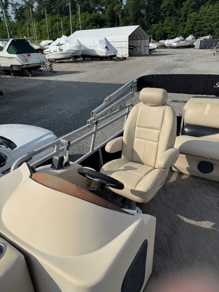 Slide: The Image of Interior view of a Bentley Pontoons Elite 25 with beige seating and steering wheel. - 5