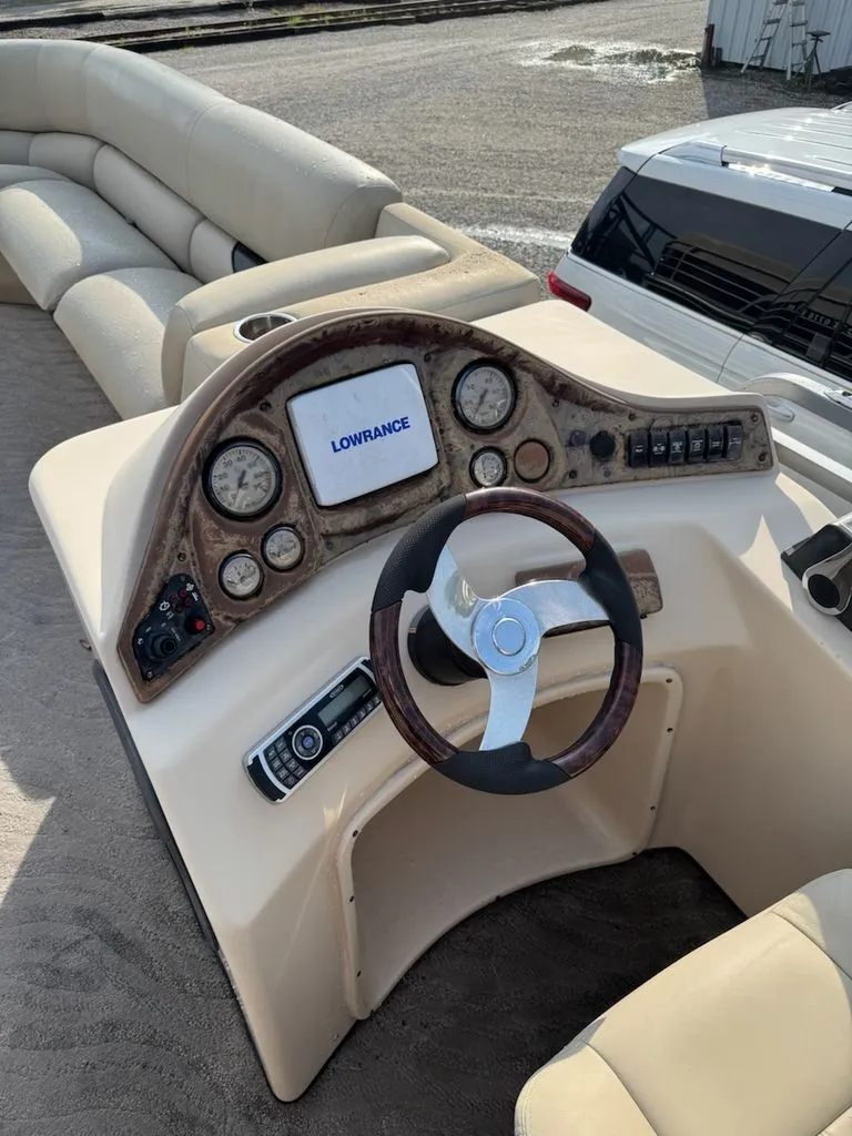 Slide: The Image of The image shows the helm of a 2014 Bentley Pontoons Elite 25 with a Lowrance screen. - 4