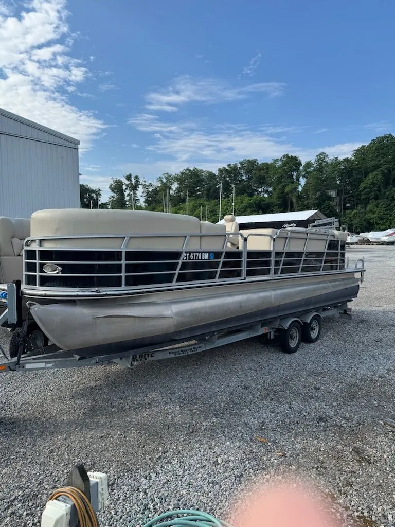 Slide: The Image of A 2014 Bentley Pontoons Elite 25 on a trailer in a gravel lot. - 12