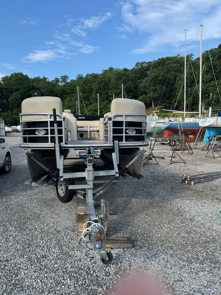 Slide: The Image of A 2014 Bentley Pontoons Elite 25 on a trailer in a gravel lot. - 10