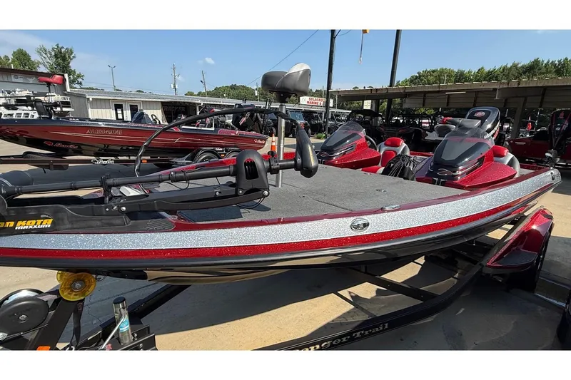 Slide: The Image of 2014 Ranger Z118 Comanche bass boat with red and silver detailing, parked on a trailer. - 15