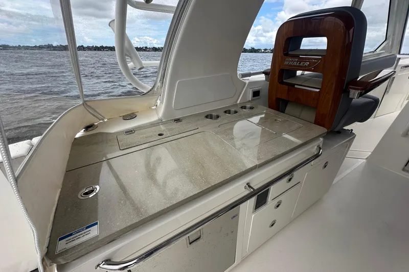 Slide: The Image of 2024 Boston Whaler 380 Realm interior with sleek countertop and seating, overlooking water. - 7