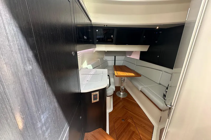 Slide: The Image of Interior of 2024 Boston Whaler 380 Realm with sleek seating and wooden table. - 16