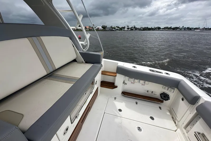 Slide: The Image of 2024 Boston Whaler 380 Realm boat interior with cushioned seating and ocean view. - 4