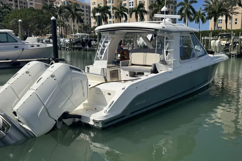 Slide: The Image of 2024 Boston Whaler 380 Realm boat docked in marina with twin Mercury engines. - 2