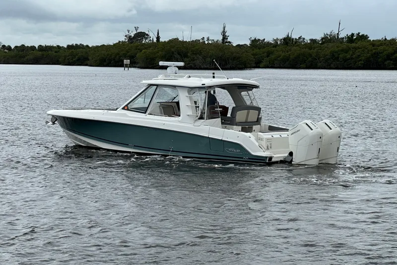 Slide: The Image of 2024 Boston Whaler 380 Realm boat cruising on a calm waterway. - 1