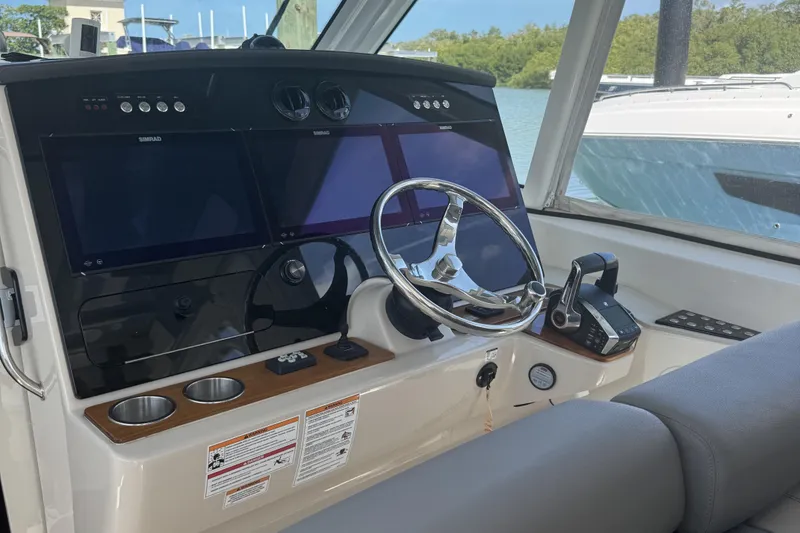 Slide: The Image of 2024 Boston Whaler 380 Realm helm with dual Simrad displays and modern controls. - 12