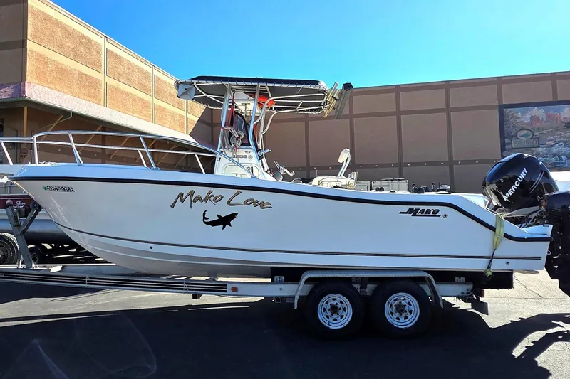The Image of 2006 Mako 252 Center Console boat on trailer, featuring "Mako Love" decal and Mercury engine. - 1