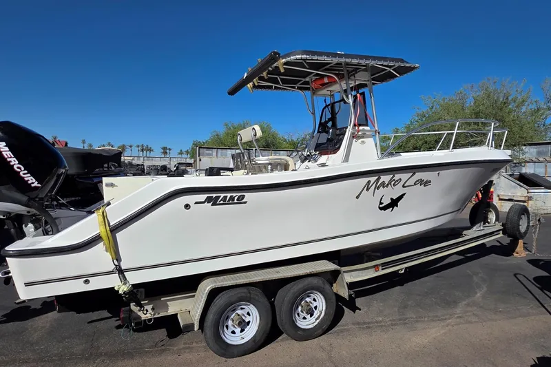 Slide: The Image of 2006 Mako 252 Center Console boat on trailer, featuring Mercury engine, clear sky background. - 3