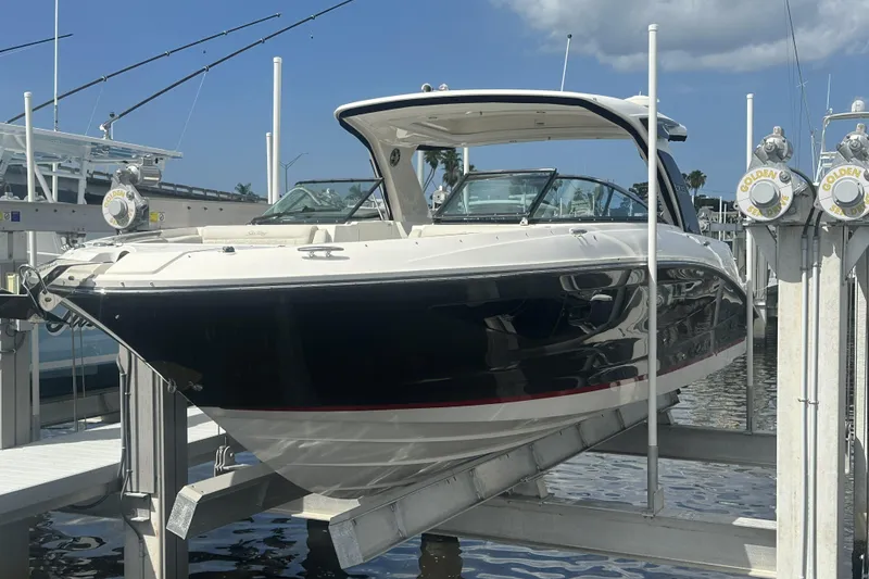 Slide: The Image of 2020 Sea Ray SLX 350 Outboard boat docked at marina under clear blue sky. - 2