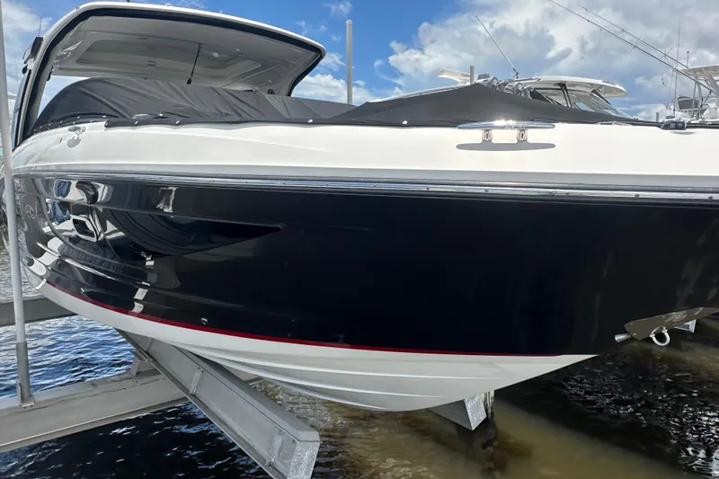 Slide: The Image of 2020 Sea Ray SLX 350 Outboard boat on lift, under blue sky. - 1