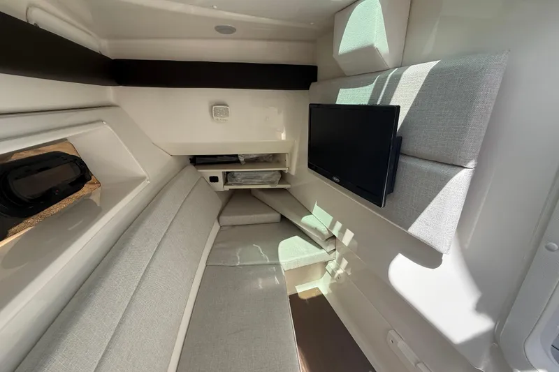 Slide: The Image of 2020 Sea Ray SLX 350 Outboard cabin interior with seating and mounted TV. - 14