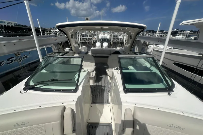Slide: The Image of 2020 Sea Ray SLX 350 Outboard boat docked, showcasing sleek design and spacious seating. - 11