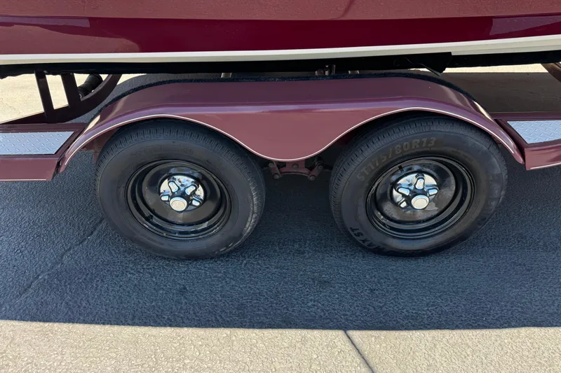 Slide: The Image of Trailer wheels of a 2010 Tahoe 195 boat on pavement. - 26