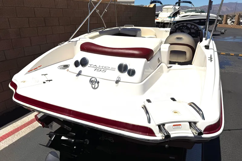 Slide: The Image of 2010 Tahoe 195 boat with red and white interior, parked outdoors. - 6