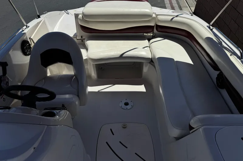 Slide: The Image of Interior of a 2010 Tahoe 195 boat featuring white seating and steering area. - 16