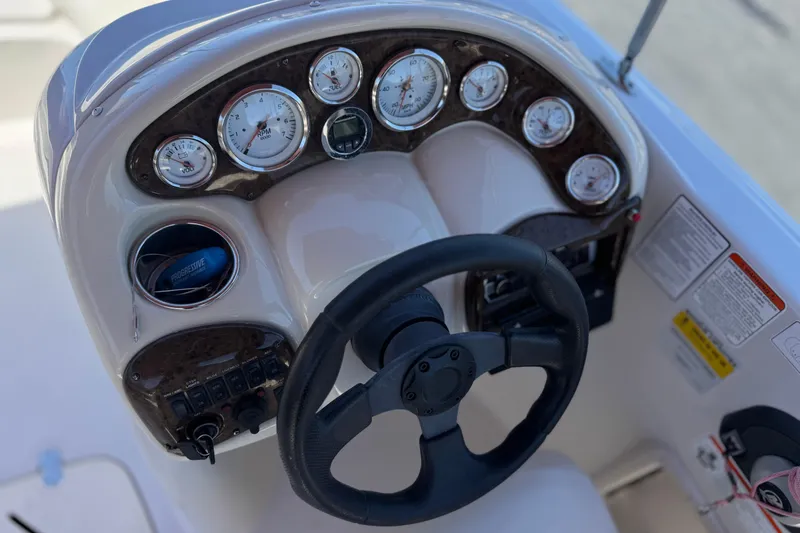 Slide: The Image of Steering console of a 2010 Tahoe 195 boat with gauges and controls. - 25