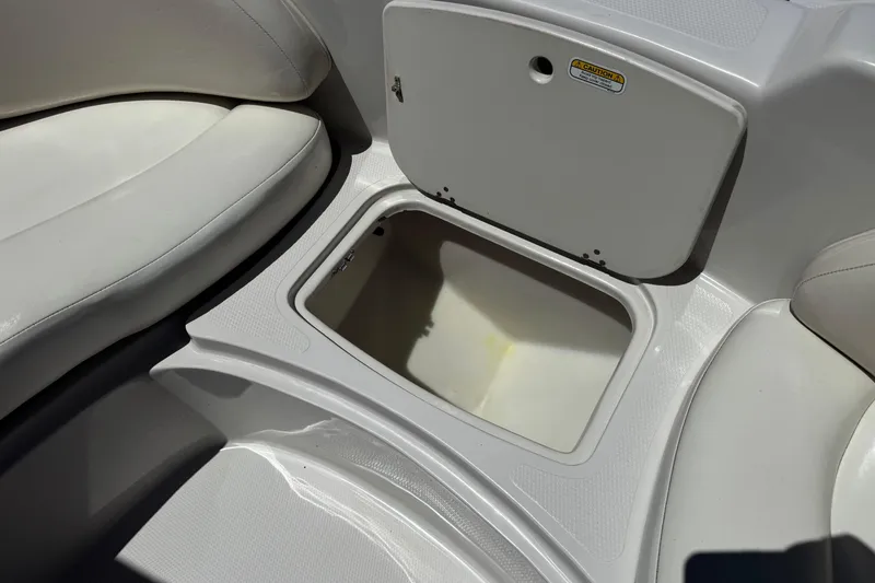 Slide: The Image of Open storage compartment in 2010 Tahoe 195 boat, featuring white interior design. - 13