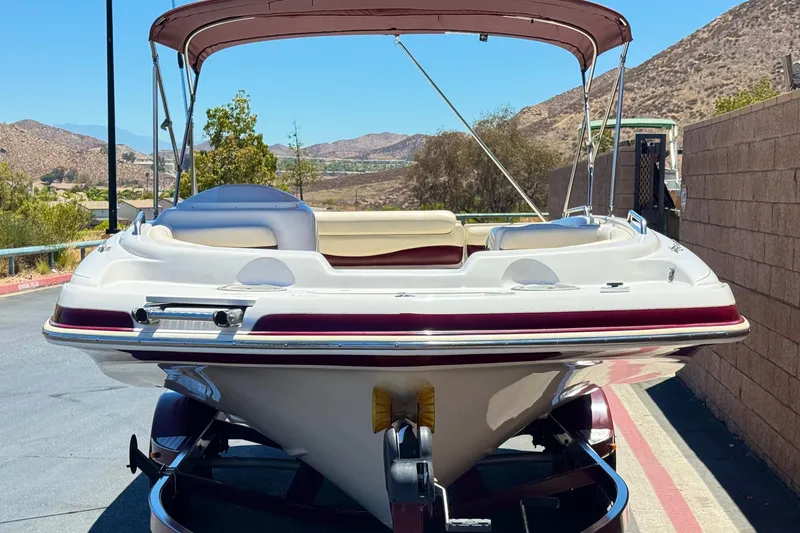 Slide: The Image of 2010 Tahoe 195 boat with canopy on trailer, parked outdoors. - 2