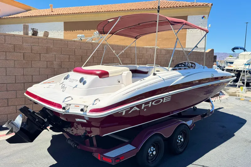Slide: The Image of 2010 Tahoe 195 boat with red and white design on a trailer, parked outdoors. - 5