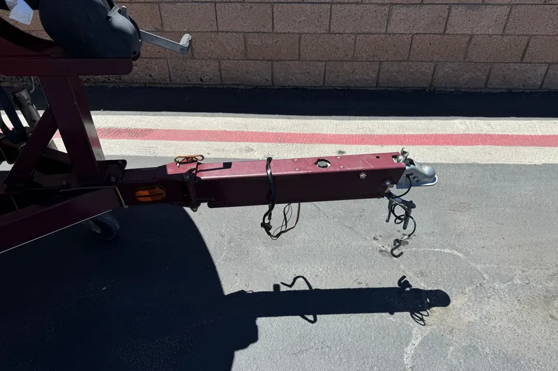 Slide: The Image of Trailer hitch of a 2010 Tahoe 195 boat, parked on asphalt near a brick wall. - 27