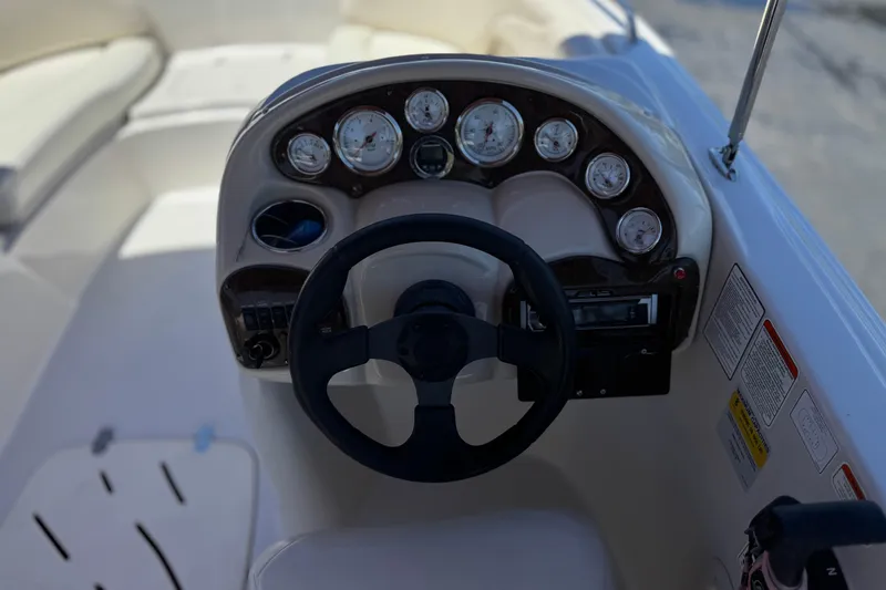 Slide: The Image of Steering console of a 2010 Tahoe 195 boat with gauges and controls. - 24