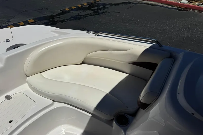 Slide: The Image of White leather seating on a 2010 Tahoe 195 boat, featuring sleek design and cup holder. - 12
