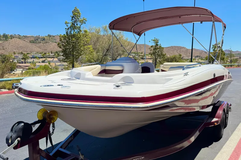Slide: The Image of 2010 Tahoe 195 boat with canopy on trailer, set against a scenic background. - 3