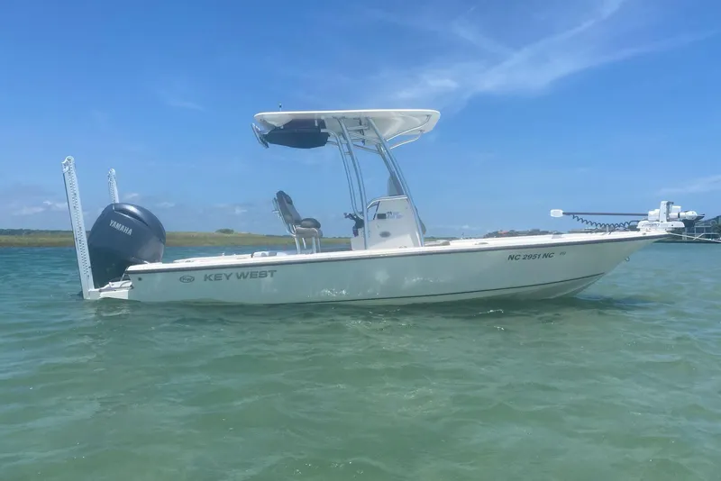 The Image of 2024 Key West 230 Bay Reef boat on calm water under clear blue sky. - 0