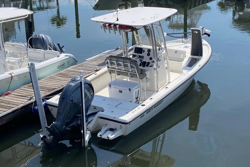 Slide: The Image of 2024 Key West 230 Bay Reef boat docked, featuring a Yamaha outboard motor. - 2
