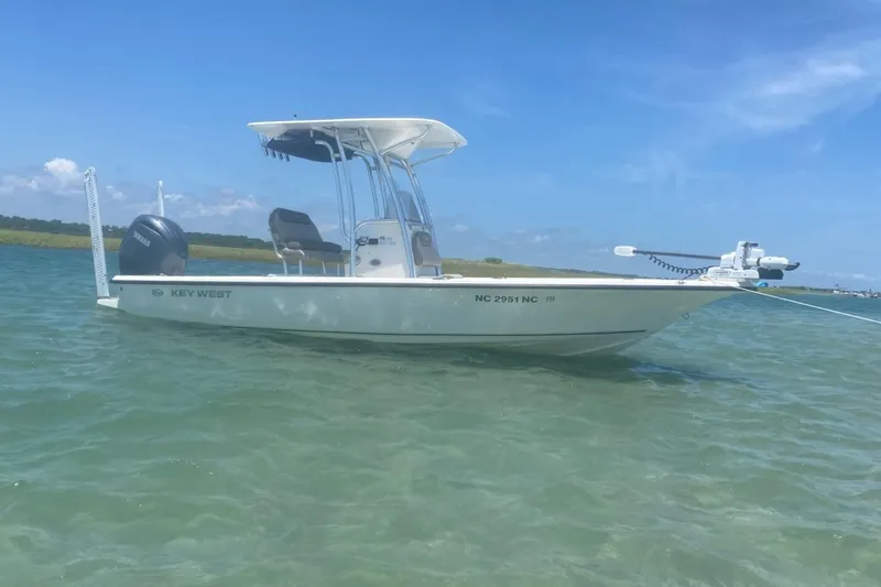 Slide: The Image of 2024 Key West 230 Bay Reef boat anchored in clear water under a blue sky. - 1