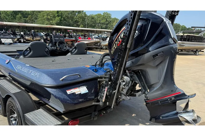Slide: The Image of 2022 Skeeter ZXR20 SE boat with powerful outboard motor, parked on a trailer. - 2