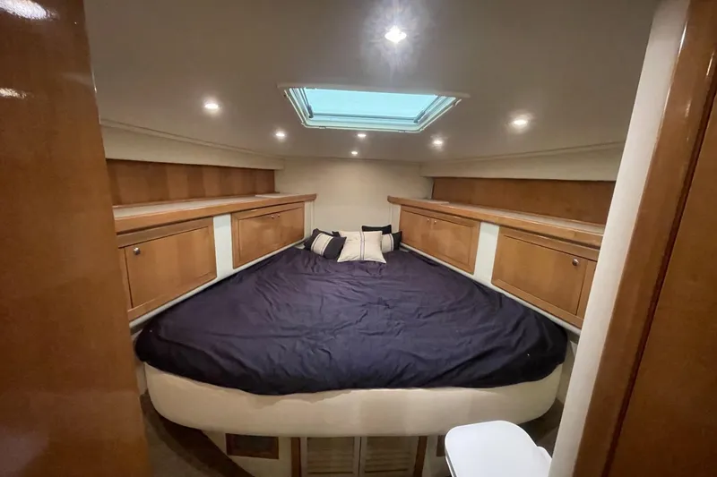 Slide: The Image of Luxurious cabin interior of a 1990 Cary 50 yacht with cozy bedding and wooden storage. - 35